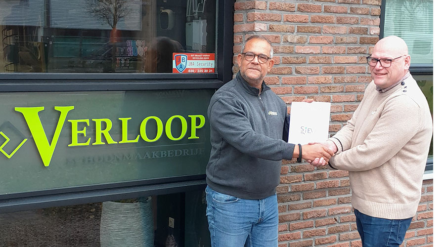 Keurmerk-toetser Edgar van Engelen overhandigt het SIEV Keurmerk-certificaat aan Gwan Garcia VGM,  functionaris bij Verloop schoonmaakbedrijf BV.